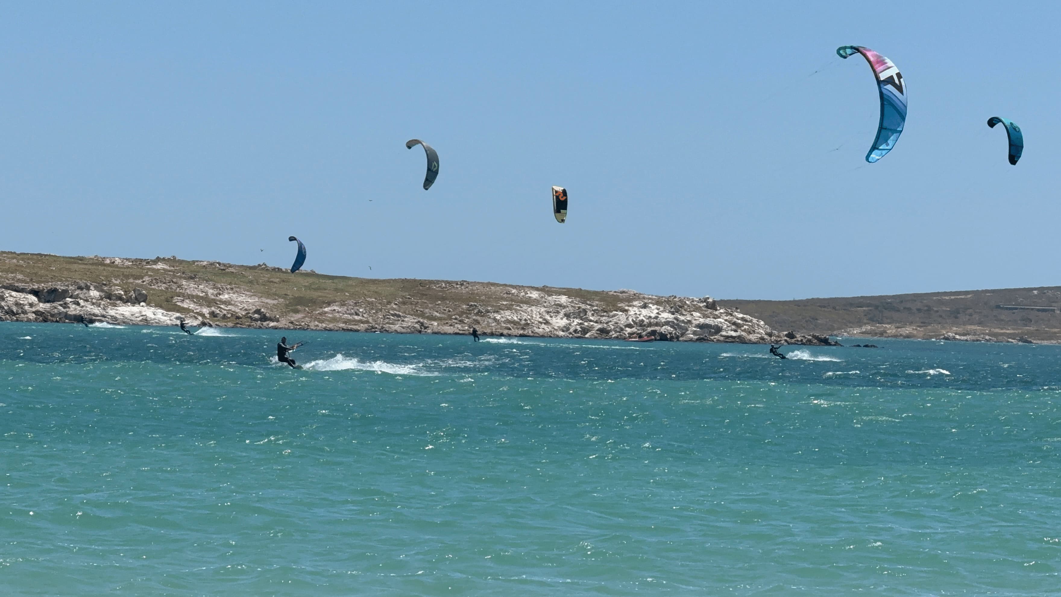 Kitesurfers riding past the rocky point at Shark Bay